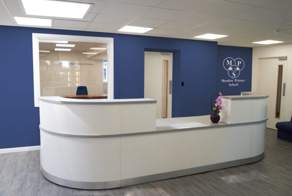 School reception area with a feature wall and large reception desk